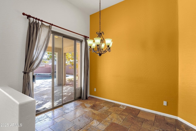 spare room with an inviting chandelier and a towering ceiling