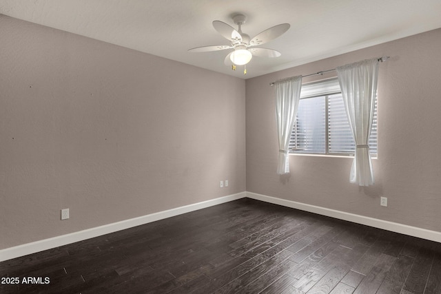 spare room featuring dark wood-type flooring and ceiling fan