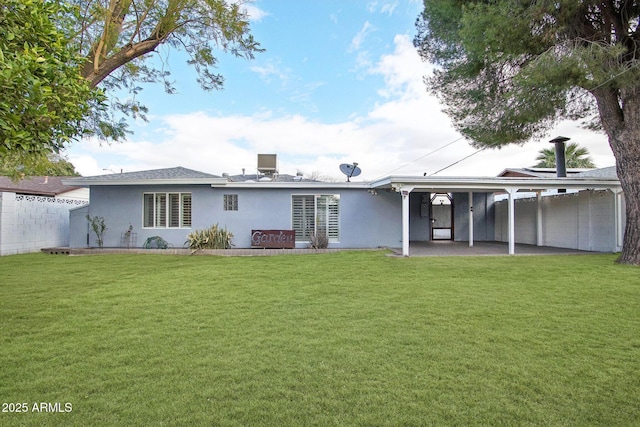 rear view of property with a yard, fence, a patio, and stucco siding