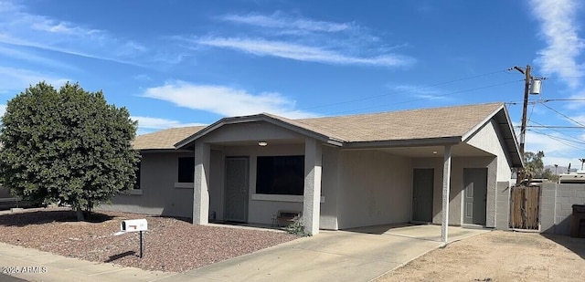 ranch-style house featuring an attached carport, roof with shingles, and stucco siding