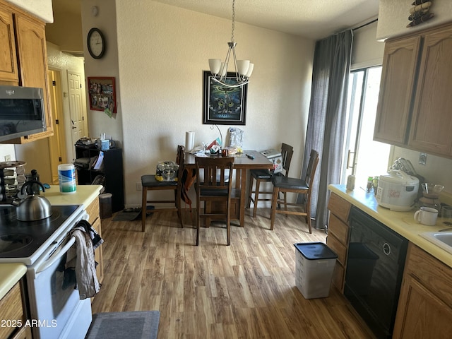 kitchen with white electric stove, light countertops, dishwasher, stainless steel microwave, and pendant lighting