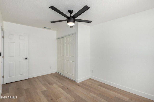 unfurnished bedroom with baseboards, visible vents, light wood-type flooring, and a closet