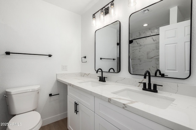 bathroom featuring wood finished floors, visible vents, toilet, and a sink