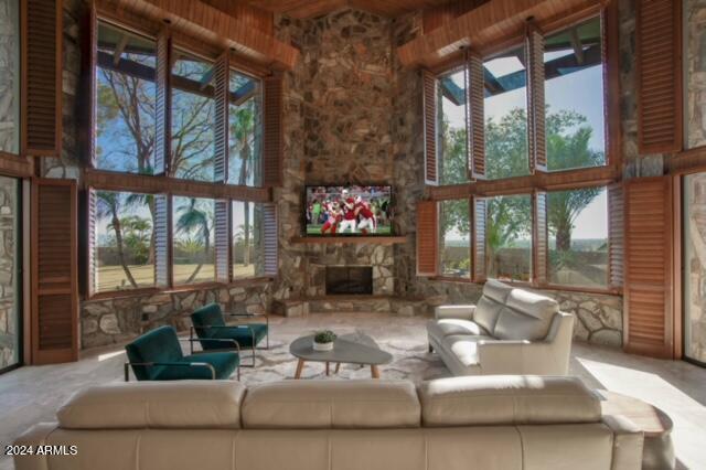 unfurnished living room with a wealth of natural light, a fireplace, and a towering ceiling