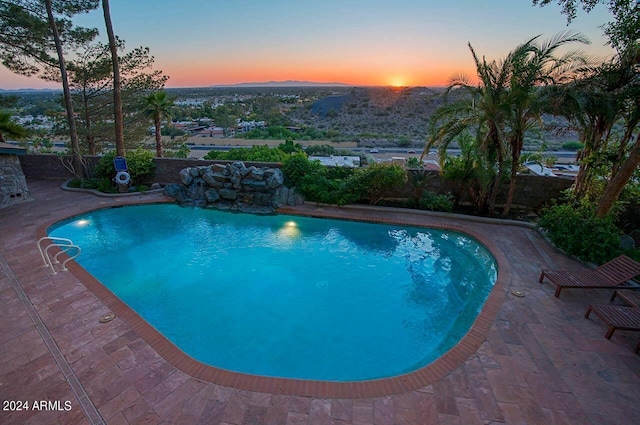 pool at dusk featuring a patio area