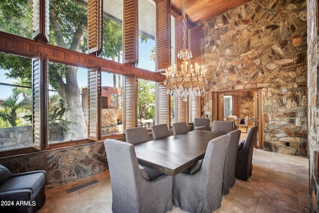 dining space with wooden ceiling, a towering ceiling, and a chandelier