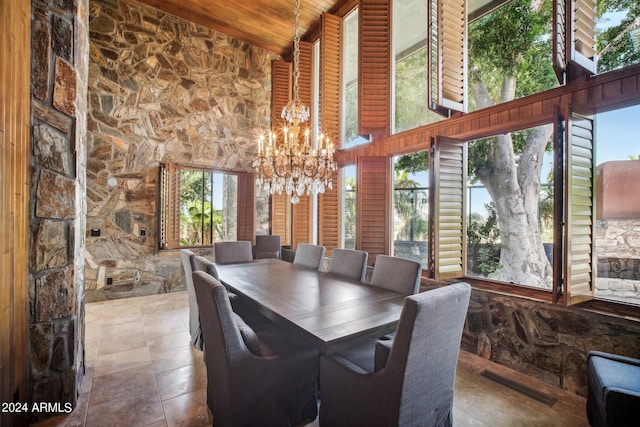 dining space featuring beamed ceiling, a high ceiling, and a notable chandelier