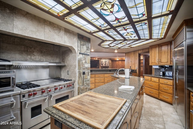 kitchen featuring sink, high quality appliances, and an island with sink