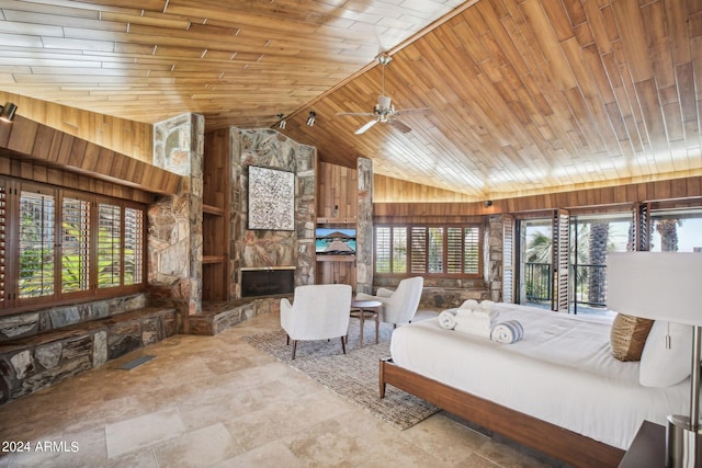 bedroom featuring wooden walls, lofted ceiling, a fireplace, and wood ceiling