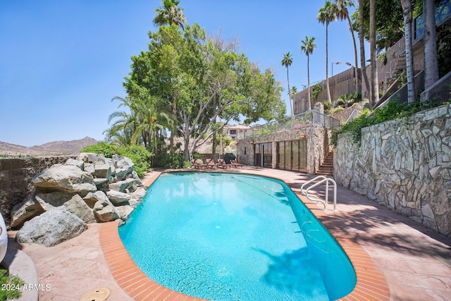 view of swimming pool with a mountain view