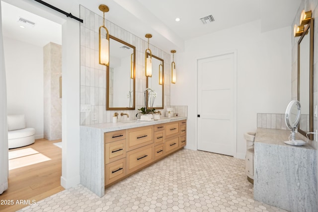 full bath with double vanity, visible vents, a sink, and recessed lighting