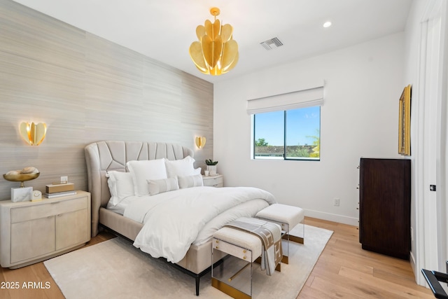 bedroom featuring visible vents, an accent wall, baseboards, light wood-style floors, and recessed lighting