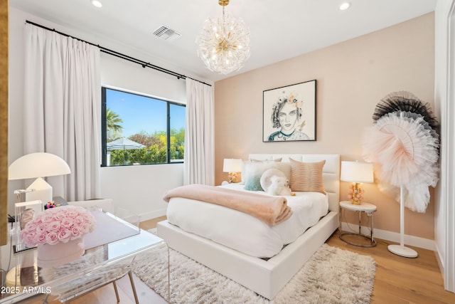 bedroom with visible vents, wood finished floors, baseboards, an inviting chandelier, and recessed lighting
