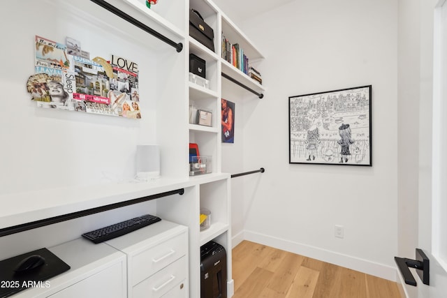 laundry area featuring laundry area, baseboards, and light wood-style floors