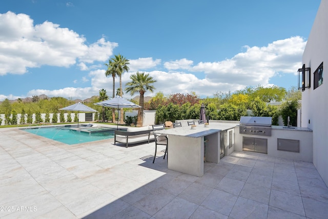 view of patio with a sink, a grill, exterior kitchen, outdoor wet bar, and a pool with connected hot tub