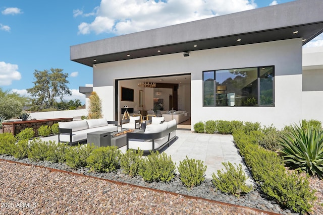 rear view of property with a patio area, outdoor lounge area, and stucco siding