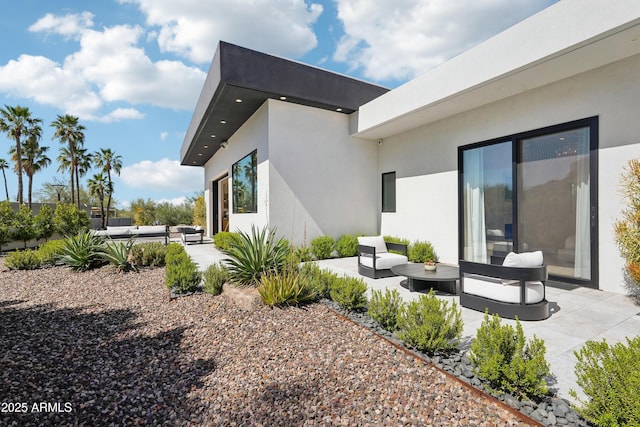back of property featuring a patio, stucco siding, and an outdoor living space