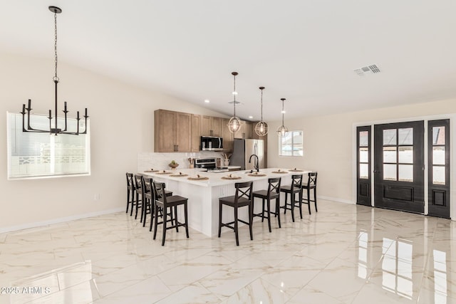 kitchen with marble finish floor, visible vents, a kitchen bar, and appliances with stainless steel finishes