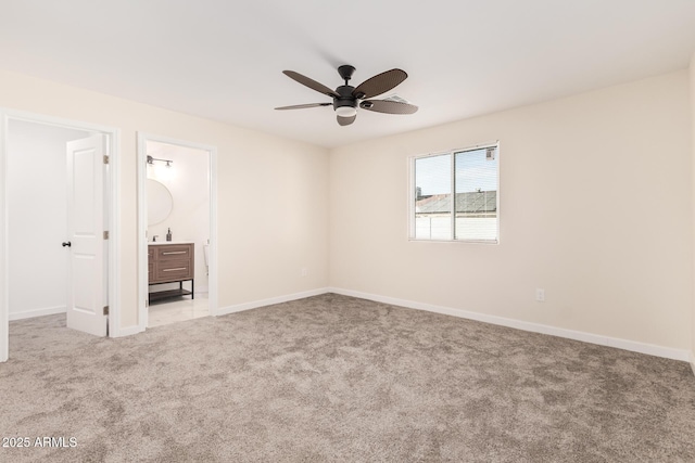 unfurnished bedroom with carpet floors, ensuite bath, baseboards, and a ceiling fan