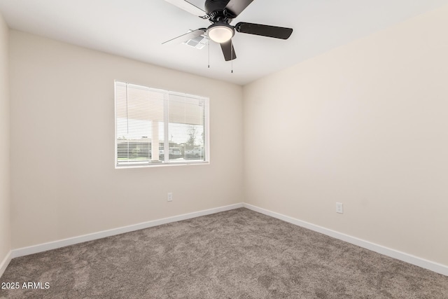 carpeted spare room with visible vents, baseboards, and a ceiling fan