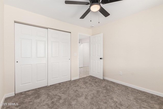 unfurnished bedroom featuring ceiling fan, carpet floors, a closet, and baseboards