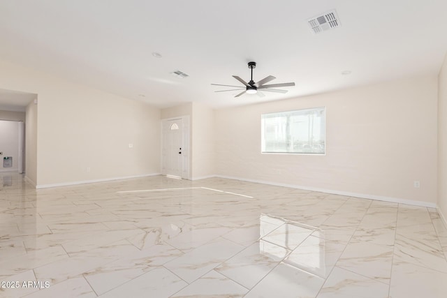 spare room with marble finish floor, baseboards, and visible vents