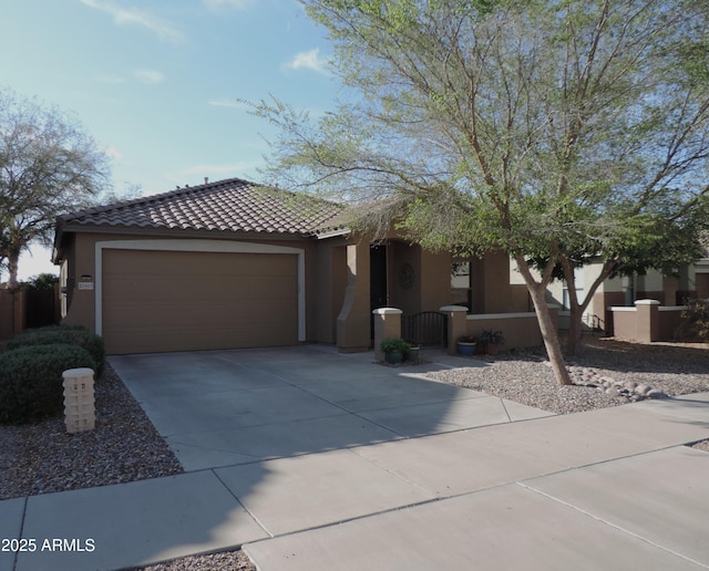 view of front of property featuring stucco siding, driveway, a gate, a tile roof, and an attached garage