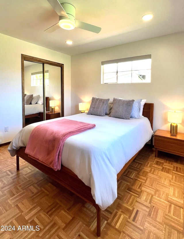 bedroom with ceiling fan, a closet, and parquet floors