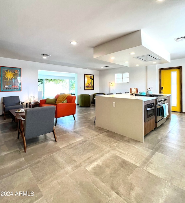 kitchen featuring high end stainless steel range and an island with sink