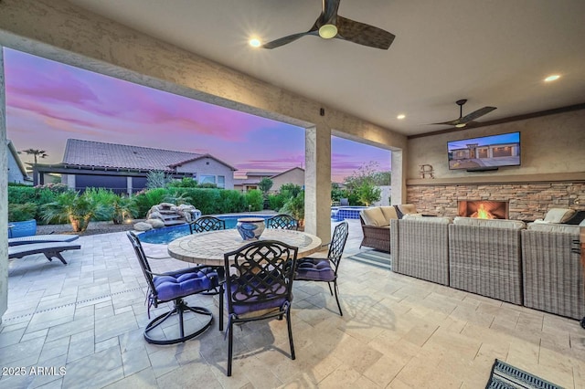 view of patio featuring a fenced in pool, an outdoor living space with a fireplace, and ceiling fan