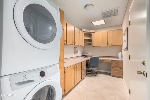 washroom featuring stacked washer and clothes dryer, a textured ceiling, and light tile patterned floors