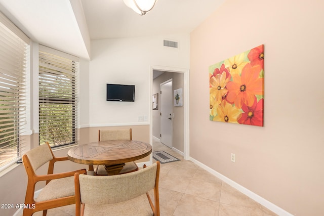 dining area with vaulted ceiling and light tile patterned flooring