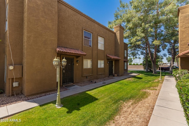 16225 N 30th St Unit 11, Phoenix, AZ 85032 - back of house with stucco siding, a yard, a chimney, and a tile roof