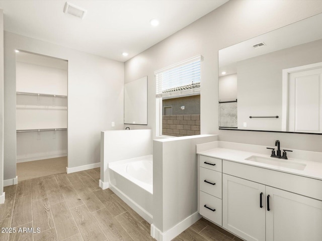 bathroom featuring vanity and a bath