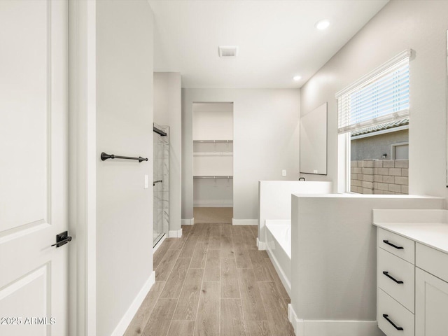 bathroom featuring vanity, separate shower and tub, and hardwood / wood-style floors