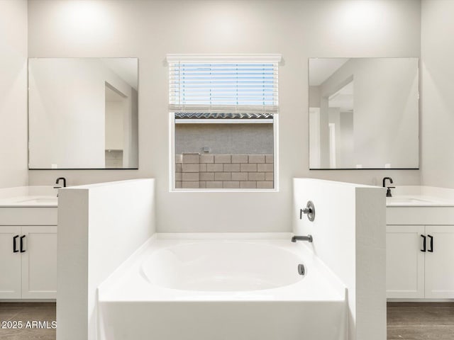 bathroom with a tub to relax in and vanity