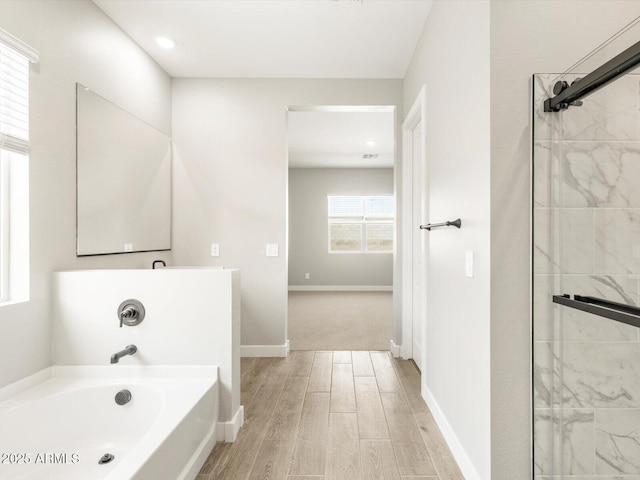 bathroom featuring hardwood / wood-style flooring and separate shower and tub