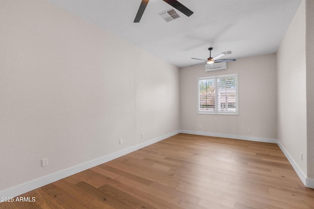 unfurnished room with ceiling fan, light hardwood / wood-style floors, and an AC wall unit