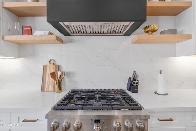 kitchen with decorative backsplash, light stone countertops, custom range hood, and white cabinets