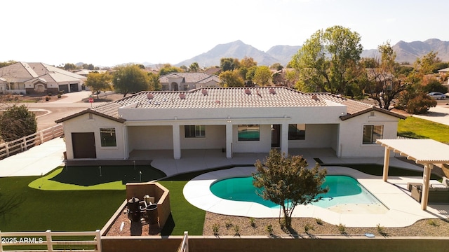 rear view of house featuring a fenced in pool, a pergola, a patio, and a mountain view