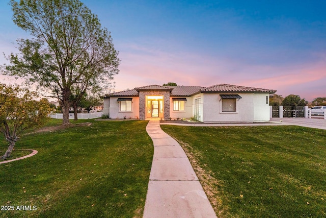 mediterranean / spanish home with a lawn