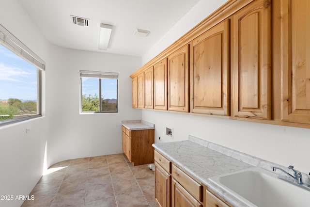 clothes washing area featuring cabinet space, washer hookup, visible vents, and a sink
