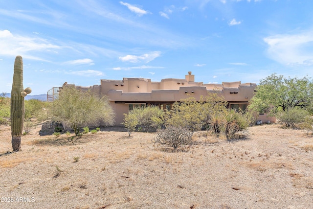 rear view of house with stucco siding