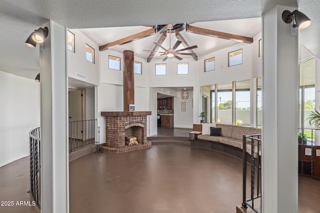 1545 E Christy Dr, Phoenix, AZ 85020 - living area featuring a ceiling fan, beamed ceiling, a high ceiling, plenty of natural light, and finished concrete floors