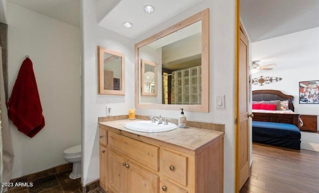 bathroom featuring wood-type flooring, ceiling fan, vanity, and toilet