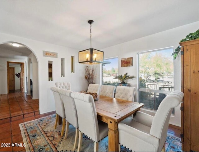 dining room with a chandelier and dark tile patterned floors