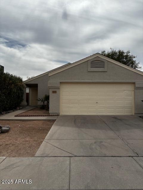 view of front of house with a garage, concrete driveway, and an outdoor structure