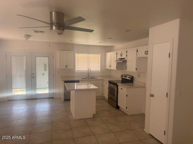 kitchen featuring stainless steel appliances, visible vents, a sink, a kitchen island, and under cabinet range hood