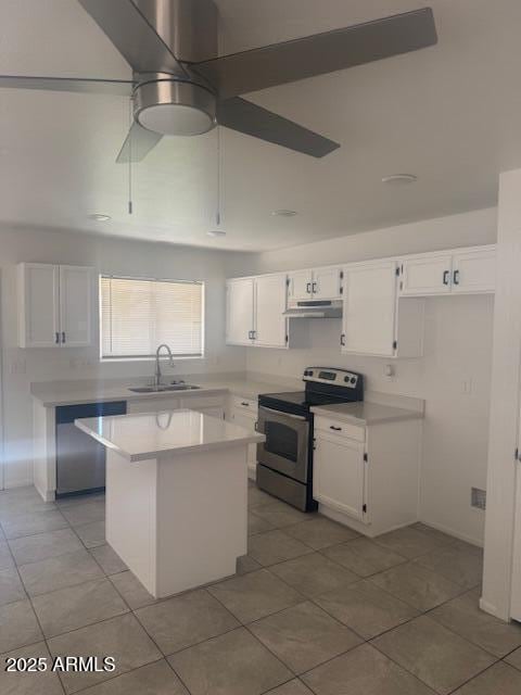 kitchen with under cabinet range hood, a sink, white cabinets, light countertops, and appliances with stainless steel finishes