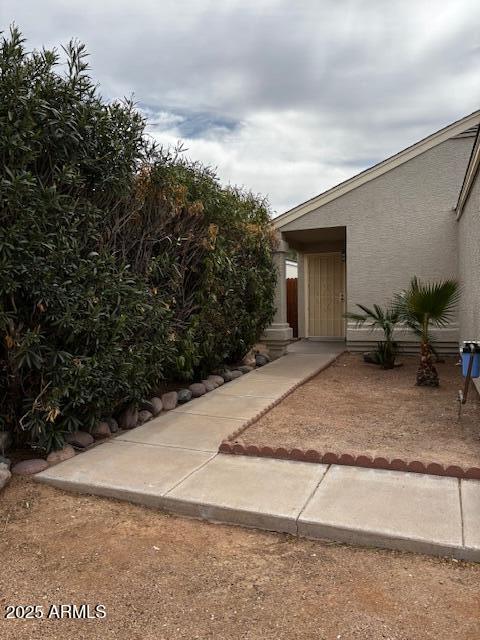 doorway to property featuring stucco siding